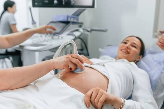 Gestante sorrindo durante ultrassom morfológico do 1º trimestre